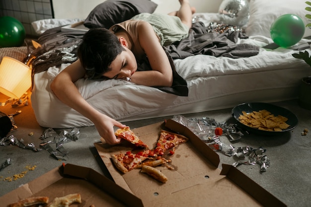 Foto adolescente comendo pizza para reduzir o efeito da ressaca