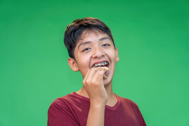 Adolescente comiendo galletas en un fondo verde