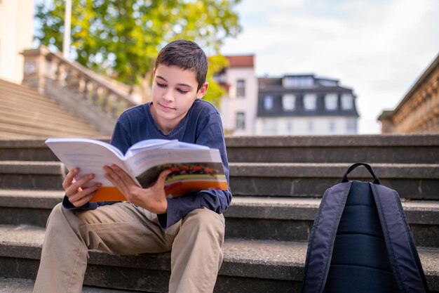 Adolescente concentrado en leer un libro de texto