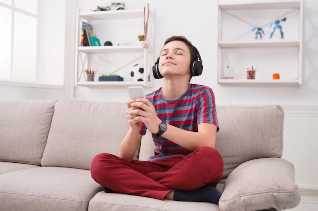 Adolescente curtindo música em fones de ouvido em casa. Hora de relaxar