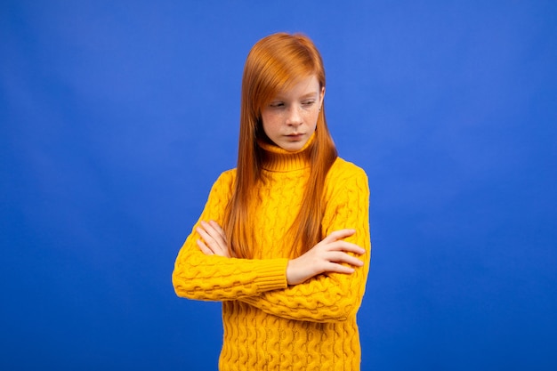 Adolescente de garota ruiva Europeia encantadora madura ofendida em um suéter amarelo azul