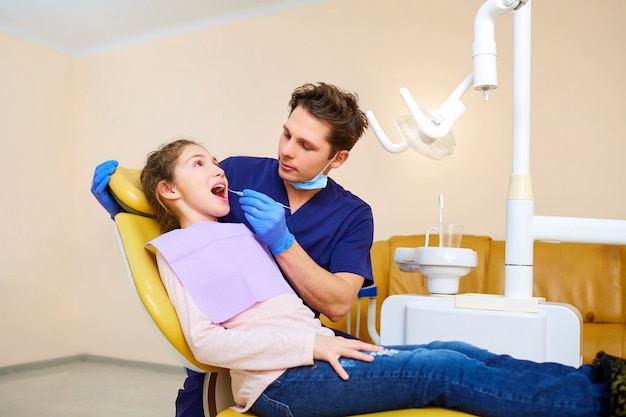 Una adolescente en un dentista en la oficina de un dentista.