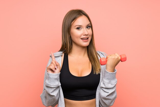 Adolescente deporte chica haciendo pesas apuntando hacia arriba una gran idea