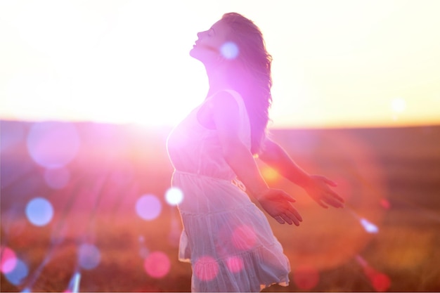 Adolescente disfruta con sol en campo de trigo