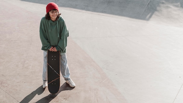 Adolescente divirtiéndose patinando en el skatepark con espacio de copia