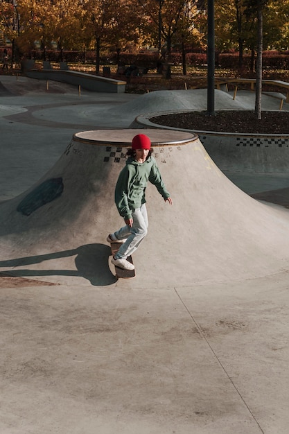 Foto adolescente divirtiéndose en patineta en el parque