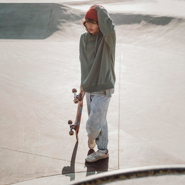 Adolescente divirtiéndose skate al aire libre en el parque