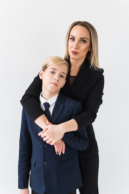 Foto adolescente e mãe solteira - jovem mãe e filho juntos na superfície branca.