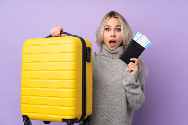 Adolescente em férias com mala e passaporte e surpreso