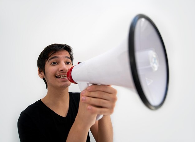 Foto adolescente em fundo branco com um megafone foto de alta qualidade