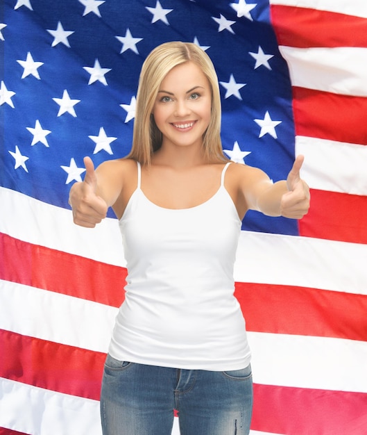 adolescente em uma camiseta branca em branco com os polegares para cima e a bandeira americana