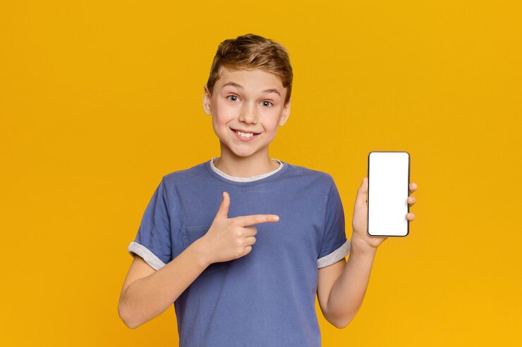 Un adolescente emocional señalando una pantalla móvil blanca y un fondo de estudio naranja sonriente