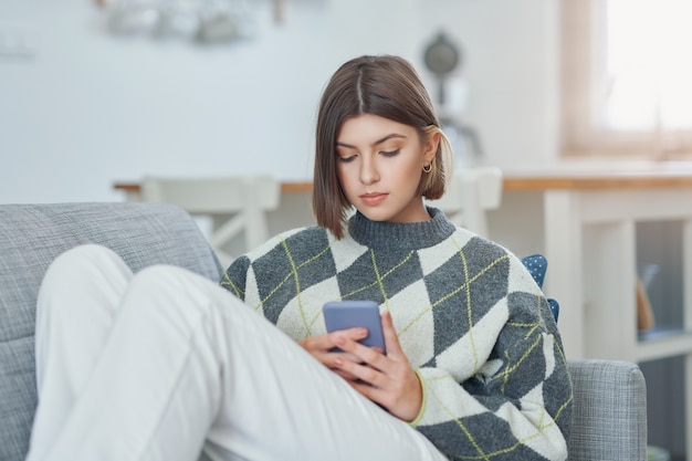 adolescente enviando mensagens de texto em casa