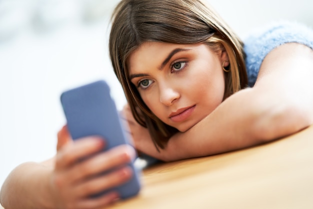 adolescente enviando mensajes de texto en casa