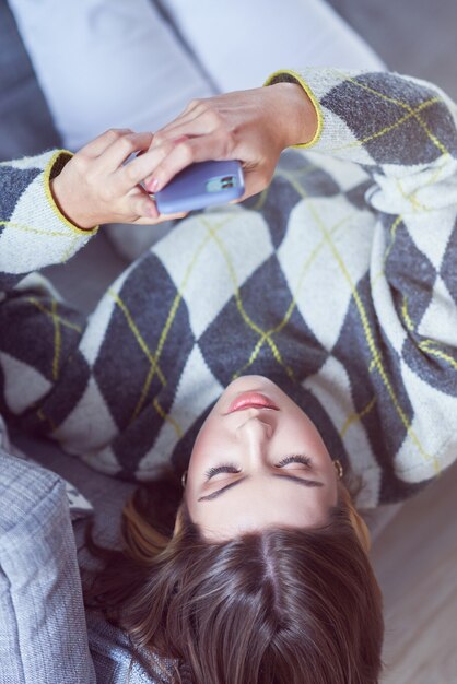 Foto adolescente enviando mensajes de texto en casa