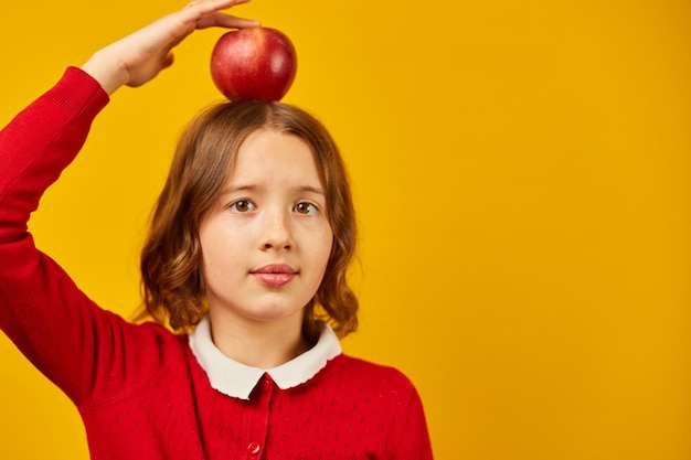 Adolescente escolar sonriente y elegante sosteniendo su cabeza sobre fondo amarillo de estudio concepto de regreso a la escuela listo para aprender