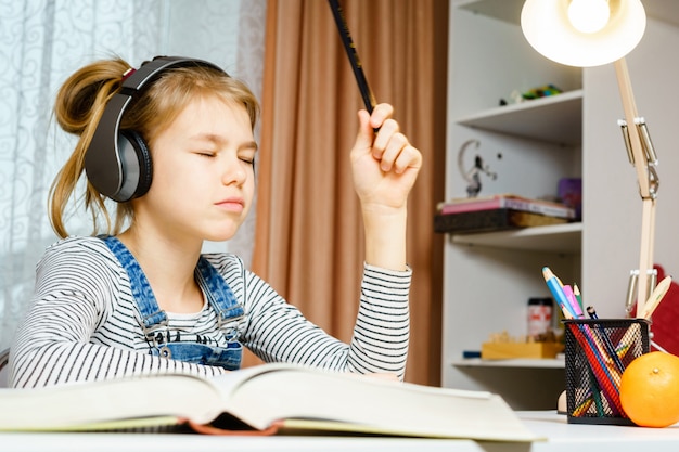 Adolescente escuchando música y haciendo tareas escolares, aprendiendo y estudiando concepto