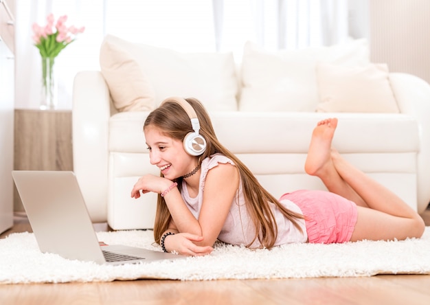 Adolescente escuchando música en su computadora portátil