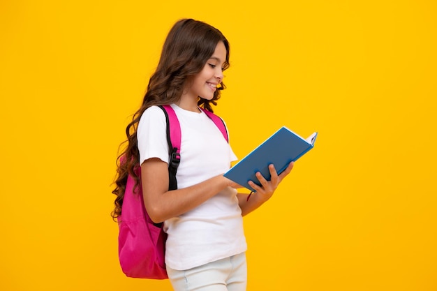 Adolescente de la escuela con mochila escolar mochila libro sobre fondo de estudio aislado amarillo Concepto de escuela y educación para niños