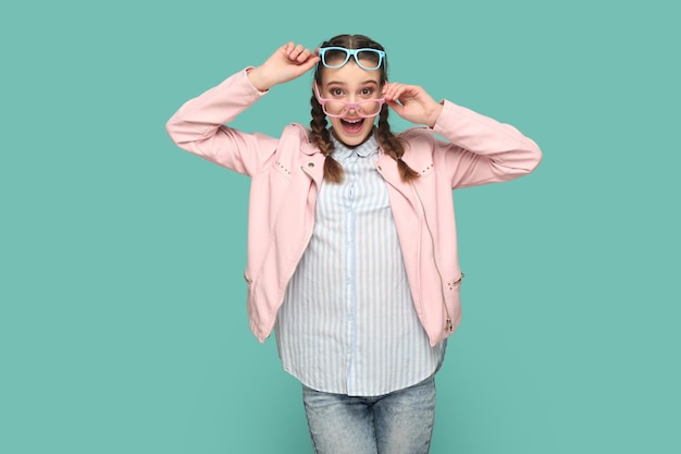 Foto adolescente espantado animado em pé em dois óculos ópticos coloridos olhando para a câmera com surpresa