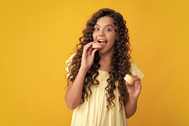 Foto adolescente espantado criança adolescente com padaria de sobremesa garoto adolescente segura macaron francês biscoito de macaroon menina adolescente excitada