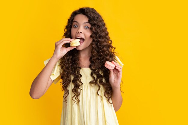 Adolescente espantado Criança adolescente com padaria de sobremesa Garoto adolescente segura macaron francês Biscoito de macaroon Menina adolescente excitada