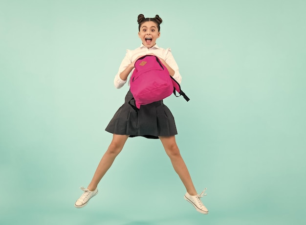 Adolescente espantado De volta à escola Aluna adolescente em uniforme escolar com mochila Saltar e correr