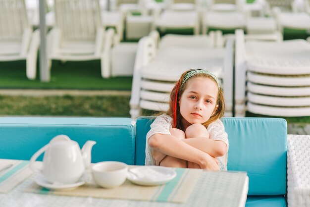 Adolescente está bebiendo té. Adolescente en un café de verano. Descanso de verano