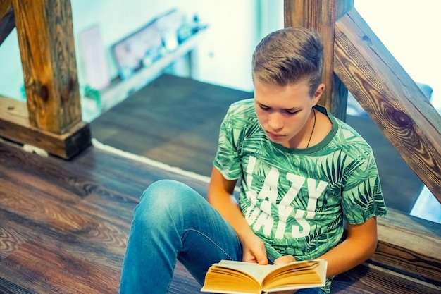 El adolescente está leyendo un enfoque selectivo de la vista superior del libro