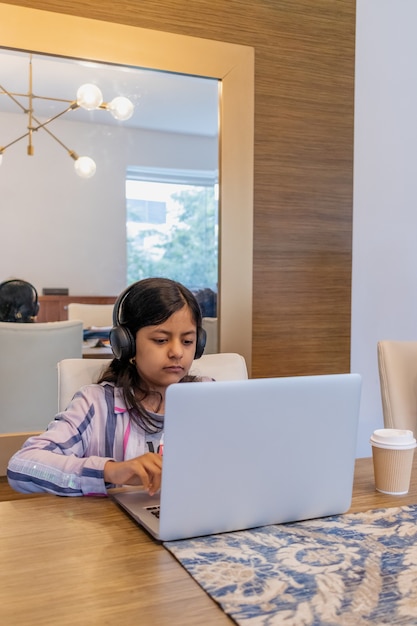 Adolescente está trabajando con su computadora portátil en su sala de estar