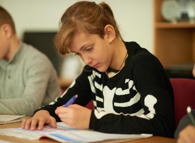 Foto adolescente estudiando en el escritorio en el aula