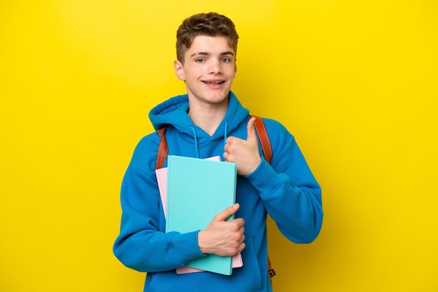 Adolescente estudiante ruso hombre aislado sobre fondo amarillo dando un gesto de aprobación