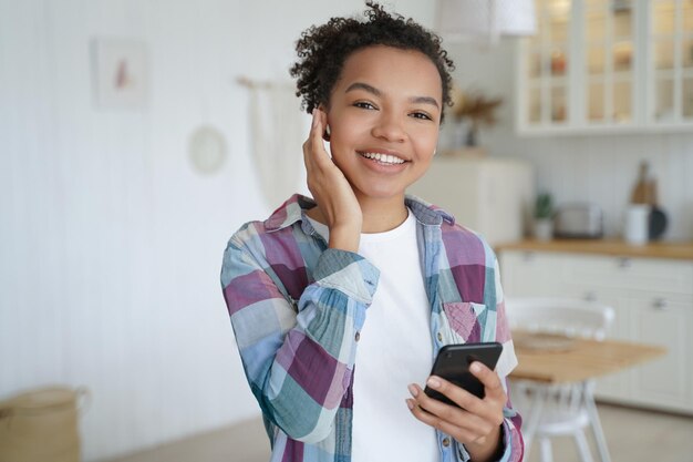 Adolescente feliz disfrutando de podcast de música escuchando en auriculares inalámbricos Recreación en casa