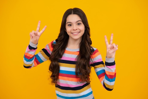 Adolescente feliz emociones positivas y sonrientes de niña adolescente Linda niña adolescente mostrando los dedos haciendo el signo de la victoria Número dos v signo paz fuerza lucha o victoria símbolo y letra v