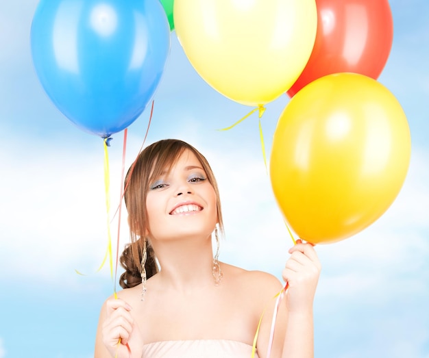 adolescente feliz con globos sobre blanco
