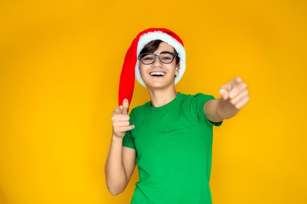 Un adolescente feliz con un gorro de Papá Noel en Nochebuena