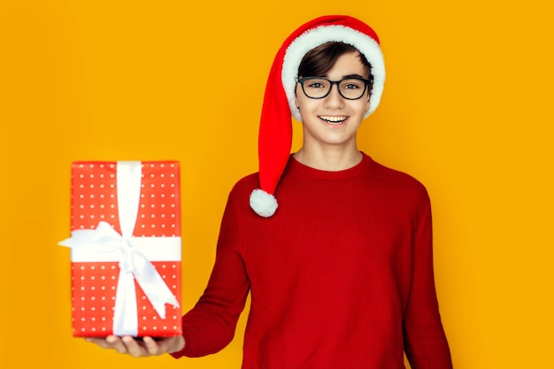 Foto adolescente feliz con gorro de papá noel con regalos de navidad