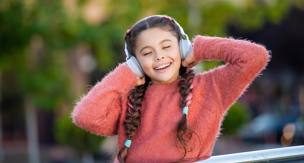 Adolescente feliz gosta de ouvir música Menina adolescente ouvindo fones de ouvido com os olhos fechados