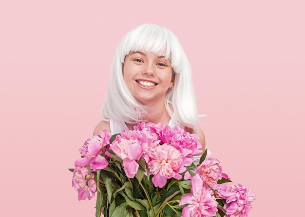 Adolescente feliz na peruca carregando flores