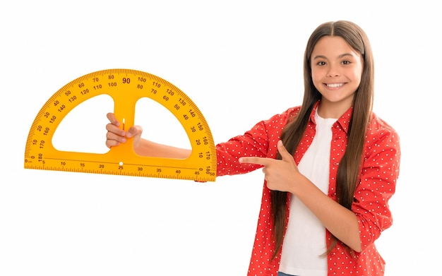 Una adolescente feliz señalando con el dedo el transportador estudia matemáticas en la escuela aislada en la educación blanca