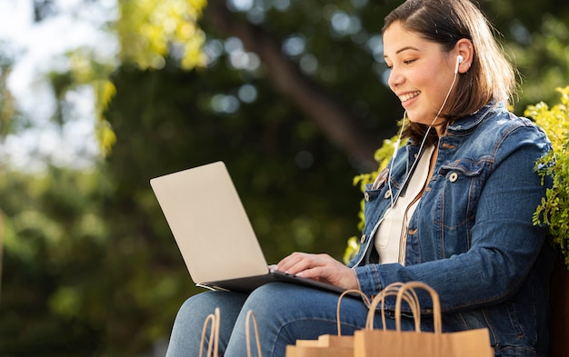 Adolescente feliz sosteniendo su computadora portátil al aire libre