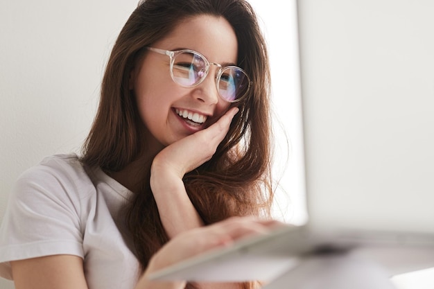 Adolescente feliz usando laptop para estudios