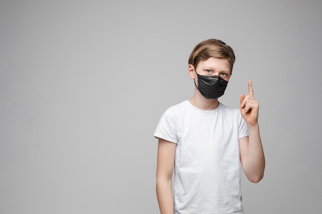 Adolescente fica na máscara médica preta, retrato isolado