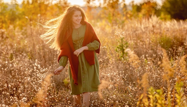 Adolescente con flores de otoño en el campo