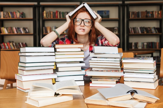 Foto adolescente frustrada sentada na biblioteca