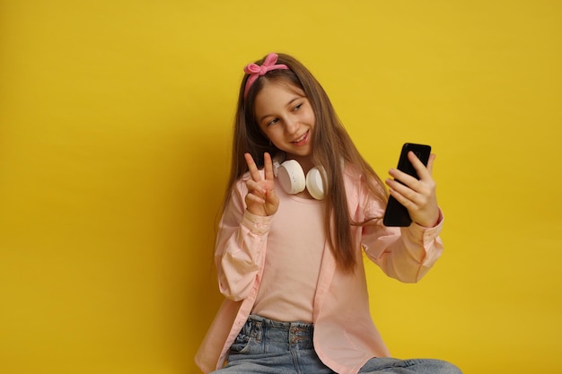 Una adolescente con gadgets, auriculares y teléfono.