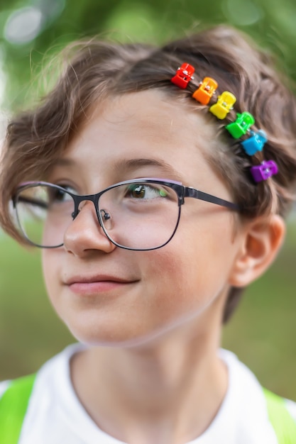 Adolescente con gafas con pinzas para el cabello de arco iris de colores, tema LGBTQ