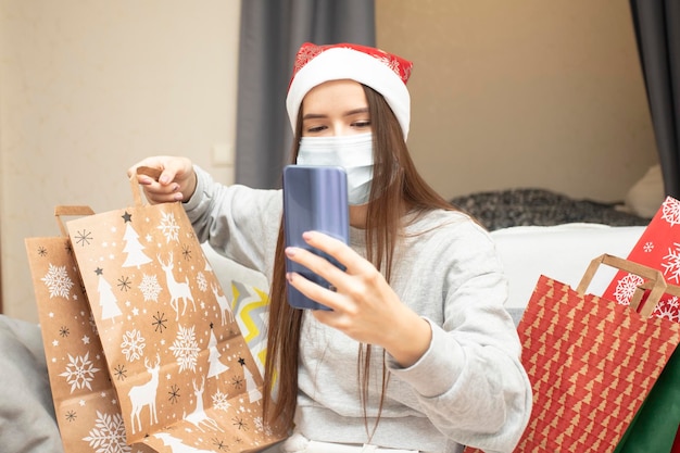 Una adolescente habla con su familia en línea a través de un enlace de video, muestra regalos y les desea una feliz Navidad y un próspero año nuevo