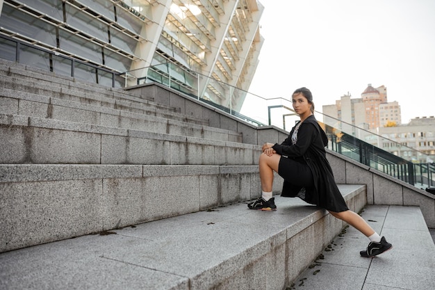 Adolescente haciendo deportes y ejercicios de estiramiento al aire libre del fondo de la ciudad