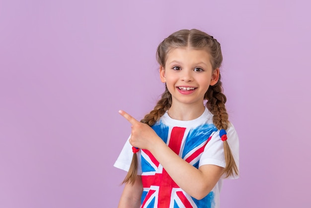 Una adolescente con una imagen de la bandera de Gran Bretaña en su camiseta señala con el dedo hacia un lado.